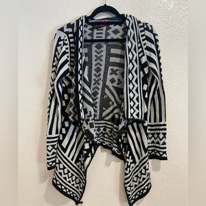 Lightly worn woman’s cardigan sweater, funky fun black and white pattern.